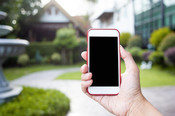 Connection technology background concept, Close up of male hands holding phone with isolated black screen in the garden. 