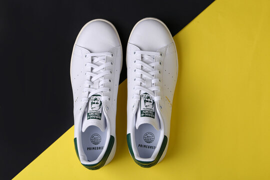 Jeddah Saudi Arabia  August 21 2021  ADIDAS stan smith endorsed by shoes, on yellow background. Product shot. Adidas is a German corporation that designs and manufactures sports shoes