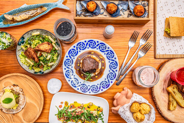Set of typical Spanish food dishes. Ham croquettes, cheek with mashed potatoes, delicatessen mussels, leek ensalada, patatas bravas.