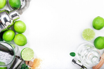 Mojito cocktail making. Mint, lime, ice, white rum, cane sugar - ingredients and bar utensils. Top view, white background. Flat lay