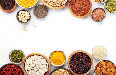Set of superfoods, legumes, cereals, nuts, seeds in bowls on white table. Copy space, top view