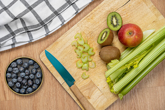 top view picture of fruits and vegetables to make detox juice with knife and kitchen towel