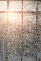 Frosty patterns on a window with a lattice on a cold winter evening. Abstract seasonal background, christmas mood