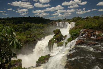 Fototapeta na wymiar Natural world wonder. The Iguazu falls in Misiones, Argentina. View of San Martin fall. The waterfall's white water falling along the rocky precipice into the jungle.