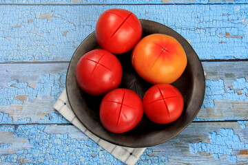 Fresh Red tomatoes are prepared for blanching. Tomatoes with cuts on a plate
