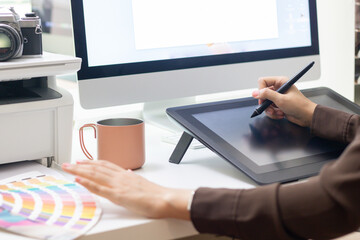 Designer woman working with graphics tablet or digitizer and color graph.