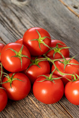 fresh ripe bunch tomatoes on wood background. Close up
