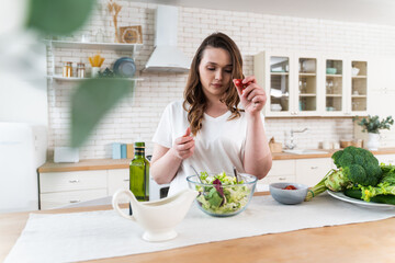Obraz na płótnie Canvas woman preparing a salad in the kitchen