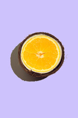 The coconut is halved, there is an orange inside