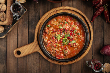 Top view on georgian chicken liver in tomato sauce with pomegranate