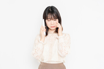 Fototapeta premium 電話の子機を持って泣いている女性