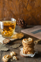 butter cookies stacked and a glass of tea on wood table background