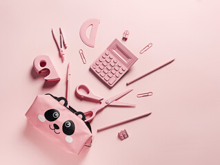 Office and school equipment in pastel pink color. Calculator, scissors, pens, pencils, staples, ruler, and panda pencil case. Girly school stationery. Back to school creative concept. Flat lay.