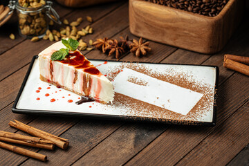 Fototapeta premium Slice of sweet cheesecake with cacao powder on wooden background