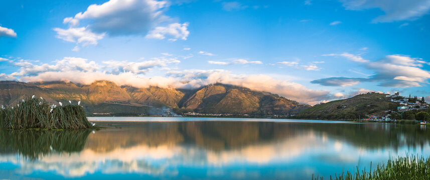 Panor&aacute;mica de Atardecer con cielo azul y fondo de monta&ntilde;as en la laguna de Yahuarcocha, provincia de Imbabura, Ecuador