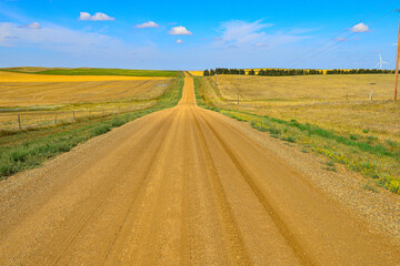 Fototapeta na wymiar Gravel road through wide open spaces in agriculture country in North Dakota.