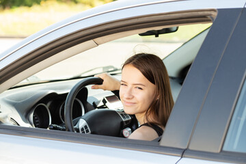 teenager in car,student driver in a driving school at a driving lesson behind the wheel of a car,girl gets a driver's license