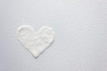 White sugar crystals in the shape of a heart. Copy space