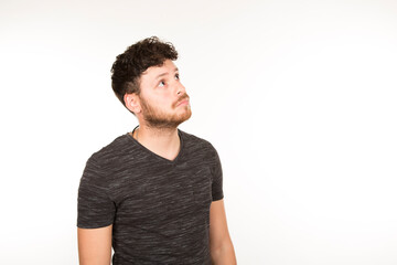 Obraz premium Caucasian young man with brunette hair with beard and looking sideways