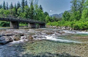 Creek with crystal clear water and a wooden bridge
