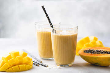 Yellow mango papaya smoothie in glass. Tasty mango lassi