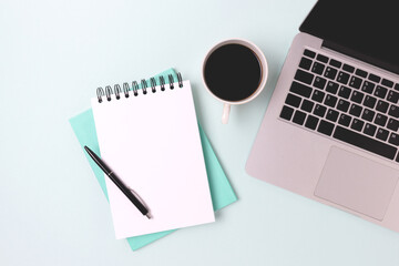 Workspace for online education with laptop and open notepad on a blue background. Online education, freelance work concept.