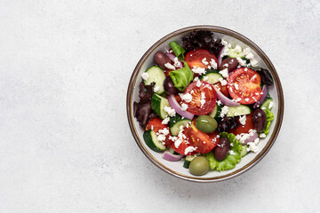 Greek salad with feta cheese and fresh vegetables on white background