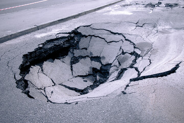 A hole in the ground in the middle of the road. A large pit in the asphalt due to a pipeline...