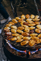Oscypek is traditional street Polish food. Goat smoked cheese with sweet raspberry jam. Street food at the Christmas night market. Baked cheese with jam on an open fire.