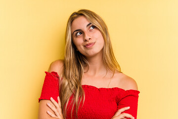 Young caucasian blonde woman isolated on yellow background  dreaming of achieving goals and purposes