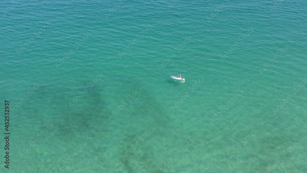 Wall mural Aerial view of white sailboat in calm turquoise sea 