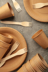 Eco friendly disposable tableware on a grey background. Vertical photo