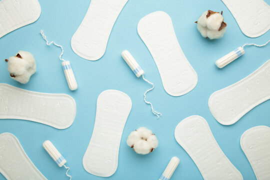 Menstrual tampons and pads on a blue background. Menstruation cycle. Hygiene and protection.