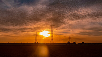 Fototapeta premium Beautiful sunset with overland high voltage lines near Tabertshausen, Bavaria, Germany
