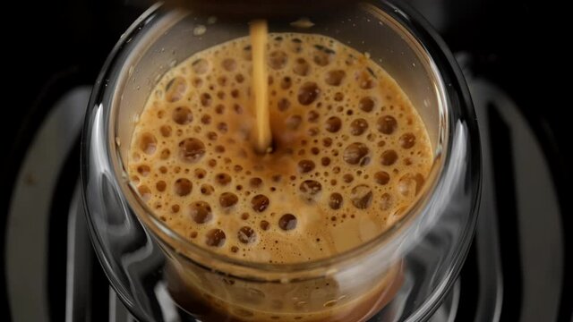 Pouring black coffee stream from machine in cup. Making hot Espresso. Automatic coffee machine with coffee capsules or coffee pods. 