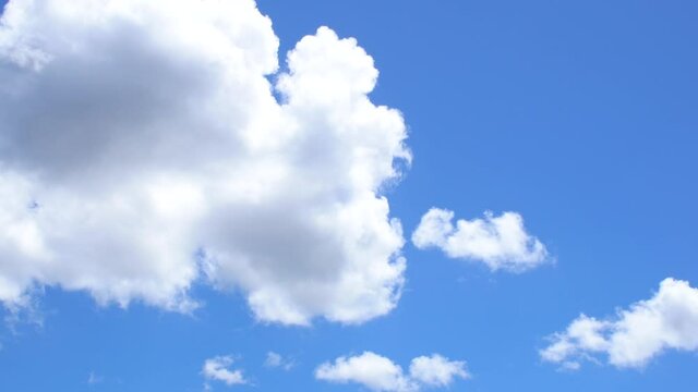 Fast movement of big white clouds in the blue sky