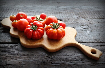 Fresh tomatoes on vintage wooden table ready for cooking