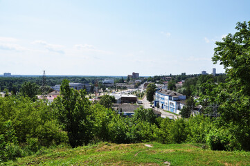 Fototapeta na wymiar Panoramic view from the dais to the city of Bryansk. Green trees and city buildings.