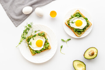 Open sandwich with avocado spinach cream and eggs. Top view
