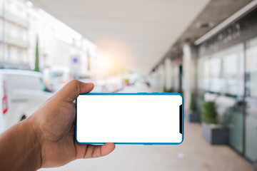 Man's hand using cellphone outdoor, Man typing text message on smart phone blurred city background