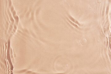 Beige water surface background. Water texture with splashes and bubbles. Summer nature background