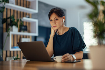 Fototapeta premium Portrait of a beautiful businesswoman working overtime at home.