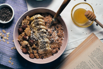 Bowl of oatmeal porridge with banana and nuts. Top view. Healthy vegan breakfast