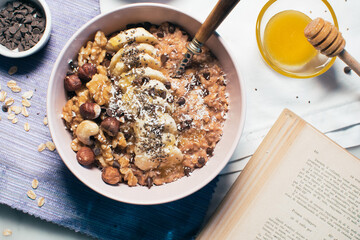 Bowl of oatmeal porridge with banana and nuts. Top view. Healthy vegan breakfast