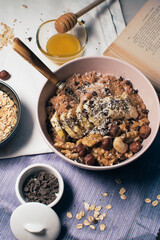 Bowl of oatmeal porridge with banana and nuts. Top view. Healthy vegan breakfast