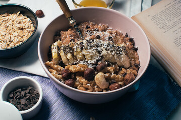 Bowl of oatmeal porridge with banana and nuts. Top view. Healthy vegan breakfast