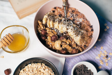 Bowl of oatmeal porridge with banana and nuts. Top view. Healthy vegan breakfast
