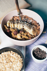 Bowl of oatmeal porridge with banana and nuts. Top view. Healthy vegan breakfast