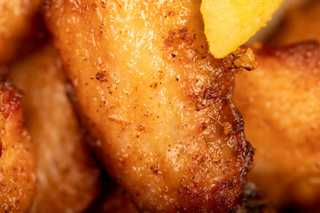 Fried chicken wings and French fries on a plate, close-up, selective focus.