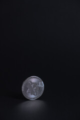 One BitCoin coin close-up with face on silver colour stand bottom centered on back background. Bitcoin BTC Digital crypto currency - Electronic Money. Digital coin international stock exchange.